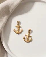 Dije de acero con baño de oro en forma de ancla con detalle de soga grabada.