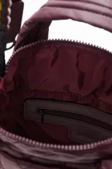 Cartera tote mini negra, con diseño matelasse y dos asas cortas. Incluye una correa larga ajustable y extraíble, con detalles de cuentas de colores.