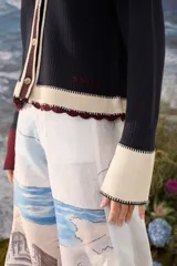 Cardigan de punto azul marino con cuello tejido a mano en crochet color crudo, cierre frontal con botones y detalles en tono borravino y crudo en los bordes y puños semióxford.