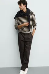 Pantalón de corte recto confeccionado en tejido elástico, con cintura elástica, pliegues frontales, bolsillos laterales y bolsillos traseros de vivo con botón.