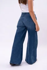 Pantalón de jean corte wide leg con costura central vertical, tiro medio y cierre frontal con botones.