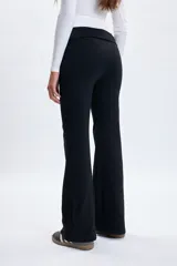 Pantalón tipo legging de corte oxford, color negro, con cintura ancha doblada y diseño ajustado en la parte superior con caída acampanada hacia el ruedo.