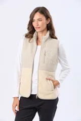 Chaleco de sherpa combinado en tonos beige, con cuello alto y cierre frontal. Presenta una textura suave y abrigada, ideal para capas adicionales.