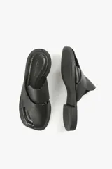 Sandalias planas de cuero color blanco hueso, con dos tiras anchas cruzadas en la parte superior y diseño minimalista.