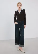 Chaleco de punto grueso color marrón, con diseño entallado, cuello camisero celeste en contraste y mangas largas.