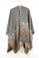 Poncho abierto color gris con diseño geométrico en tonos marrones y flecos en el borde inferior.