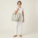 Bolso tote amplio de lona de algodón con diseño de rayas verticales en color verde y blanco, con manijas largas para llevar al hombro.