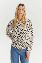 Camisa de manga larga con cuello clásico y estampado de manchas marrones sobre fondo blanco.