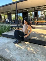 Bota corta de cuero negro con punta cuadrada y taco bloque de altura media con textura grabada. Presenta un diseño minimalista con costura central vertical y cierre lateral interno.