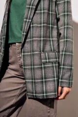 Blazer de corte recto con estampado de cuadros en tonos verdes y grises. Presenta solapas clásicas, cierre frontal y bolsillos laterales.