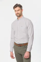 Camisa de manga larga a cuadros pequeños en tonos celeste y blanco, con bolsillo en el pecho y cuello abotonado. Corte slim fit hasta talle XL, a partir de XL classic fit.