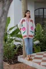 Cárdigan largo de punto color crudo con bordados florales multicolores hechos a mano.