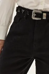 Cinturón de cuero gamuzado color camel, con diseño de tachas metálicas plateadas dispuestas en grupos triangulares y hebilla metálica labrada de estilo western.