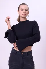 Blusa de punto acanalado color blanco, con cuello alto, corte cropped y mangas largas acampanadas.