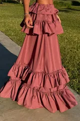 Conjunto de dos piezas compuesto por un top corto con volados en los hombros y una falda larga con múltiples niveles de volados, ambos con ajuste elástico.