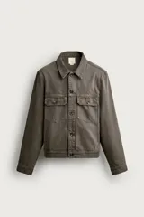 Cazadora de denim de algodón en color gris oscuro con efecto lavado, corte relaxed fit, cuello camisero, bolsillos delanteros con solapa en el pecho y cierre frontal con botones.