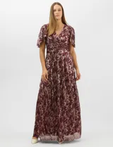 Vestido largo de fiesta con diseño cruzado, escote en V y drapeado lateral en la cintura. Presenta mangas cortas acampanadas y falda amplia con caída fluida. Confeccionado en tejido liviano con acabado plisado y estampado floral metalizado.