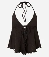 Blusa beige texturizada de corte halter con escote en V, lazo frontal ajustable en el busto y ruedo asimétrico ondulado.