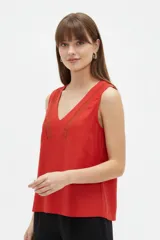 Musculosa de algodón color rojo, de bretel ancho, con escote en V y detalles de encaje aplicado alrededor del cuello.