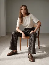 Pantalón de tiro alto confeccionado en cuero vacuno con textura croco. Presenta una silueta de pierna extra ancha, cierre frontal con botón y bolsillos laterales.