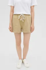 Short de algodón color beige, con cintura elástica y cordón ajustable con terminaciones de borlas.