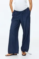 Pantalón tipo jean de corte holgado en denim suave, con diseño de piernas globo, cintura elástica con cordón de ajuste y bajos fruncidos con cordones ajustables.