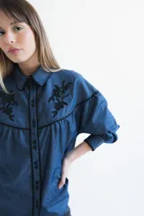 Camisa negra de manga larga con canesú estampado con diseño floral, cuello camisero y cierre frontal con botones.