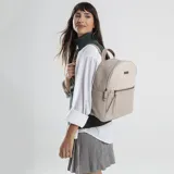 Mochila color beige con aplique simil cuero, con apertura frontal y bolsillo interno. Tiene asa de mano y correas regulables para colgar en la espalda.