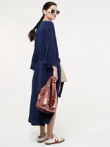 Saco largo azul marino con fajín, de jersey de lúrex con aberturas laterales, mangas largas y bolsillos laterales en costura.