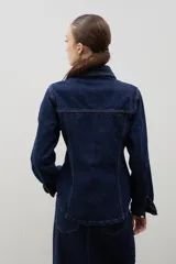 Chaqueta de denim de algodón con corte entallado en la cintura, cuello clásico, cierre frontal con botones metálicos y dos bolsillos con solapa en el pecho.