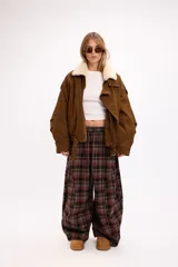 Campera de gamuza negra con cuello de piel sintética en color crema, cierre frontal, corte oversize y diseño estructurado con hombreras.