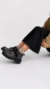 Borcego de punta redonda con cierre de velcro y cordones, con suela track dentada y acabado desgastado.