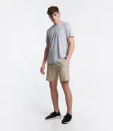 Bermuda deportiva de hombre en color beige, con cintura elástica, cordón interno para ajuste, bolsillos laterales y detalle de lettering reflectante.