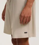 Bermuda masculina de corte recto y color beige, con cintura elástica, cordón ajustable y bolsillos laterales. Pertenece a la marca Ripping.
