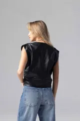 Top color beige de simil cuero liviano, con escote cruzado y acceso por cierre invisible lateral. Sin mangas con espalda cerrada y frunces en hombros.