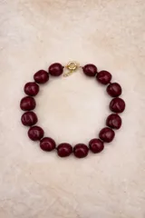 Collar de diseño artesanal compuesto por múltiples hileras de cuentas de resina pulida en una paleta de colores vibrantes que incluye tonos marrones, grises, verdes, naranjas y bordó.