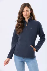 Buzo de polar color crema con cuello alto y cierre frontal parcial. Presenta detalles en cuero en el tirador del cierre y un pequeño bordado en el pecho y en la manga.