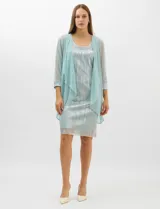 Conjunto de dos piezas compuesto por un vestido corto de silueta recta en tejido plisado metalizado con escote redondo adornado con pedrería y perlas, y una chaqueta de gasa liviana con frente abierto, caída en cascada y mangas tres cuartos con puños metalizados.