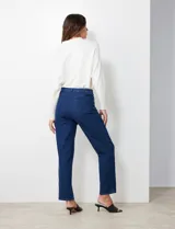 Jean de corte recto y tiro medio, confeccionado en denim elastizado de color azul oscuro. Presenta cierre frontal con botón, pasadores para cinturón y bolsillos funcionales en la parte delantera y trasera.