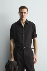 Camisa de corte relajado confeccionada en una mezcla de lana y viscosa. Presenta cuello clásico, manga larga con puños abotonados y cierre frontal con botones a tono.