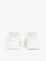 Zapatillas Tommy Hilfiger de mujer, color blanco con detalles en amarillo y verde. Presentan el logo de la marca en el lateral y están confeccionadas con una mezcla de texturas.