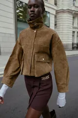 Bermuda de tiro alto color negro, con diseño de tablas frontales y detalle de eslabones metálicos dorados en la cintura. Cuenta con cierre lateral oculto.