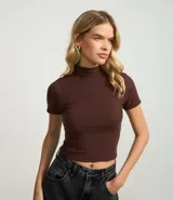 Blusa corta de cuello alto y mangas cortas, confeccionada en tejido rib texturizado color marrón.