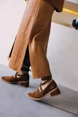 Sandalias de punta cerrada, color marrón, con taco bajo y tiras largas que se cruzan y atan alrededor del tobillo.