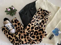 Pantalón largo de tela suave con estampado animal print en tonos beige y negro. Tiene cintura elástica con cordón ajustable.