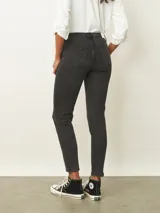 Jean de corte skinny en tono azul medio, con diseño de cinco bolsillos, cierre frontal con botón y cremallera, y costuras reforzadas.