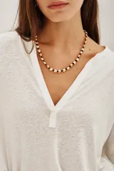 Remera de manga larga en color blanco, confeccionada en una mezcla de lino y viscosa. Presenta un escote en V con detalle de solapa y puños rectos.