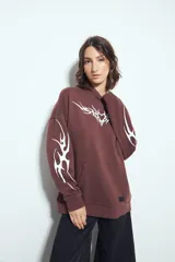 Canguro negro de silueta relajada con capucha, bolsillo canguro y estampados gráficos blancos en el pecho y las mangas.