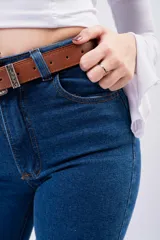 Pantalón de jean estilo Oxford de tiro alto, con ajuste en muslos y corte acampanado en la parte inferior. Presenta un lavado azul clásico y costuras reforzadas.