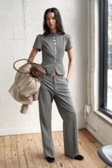 Pantalón de vestir de tiro bajo con diseño de raya diplomática. Presenta corte recto, trabillas para cinturón, bolsillos laterales y cierre frontal con cremallera, botón y ganchos metálicos.